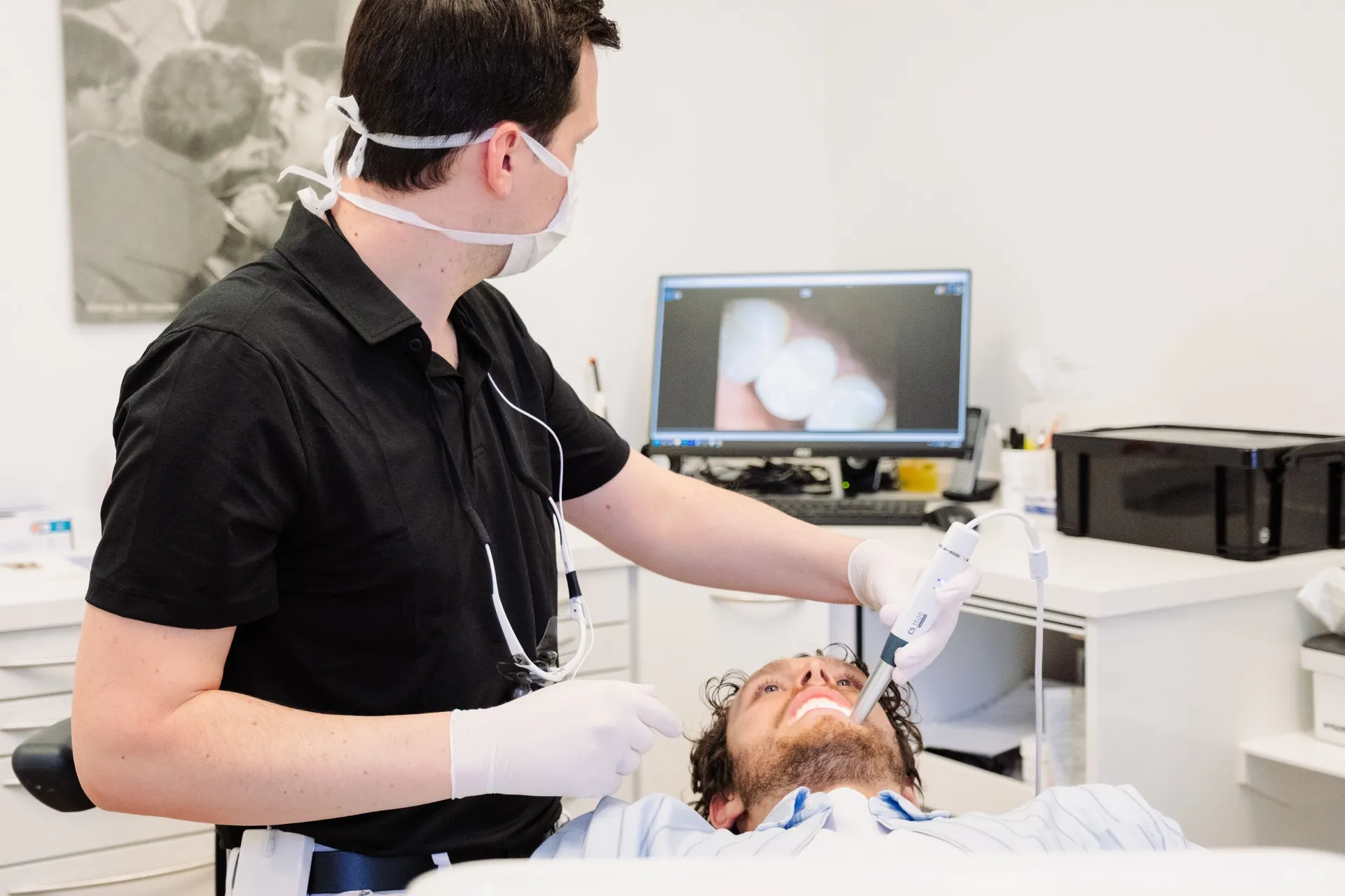 Zahnarzt bei Untersuchung mit Intraoralscanner